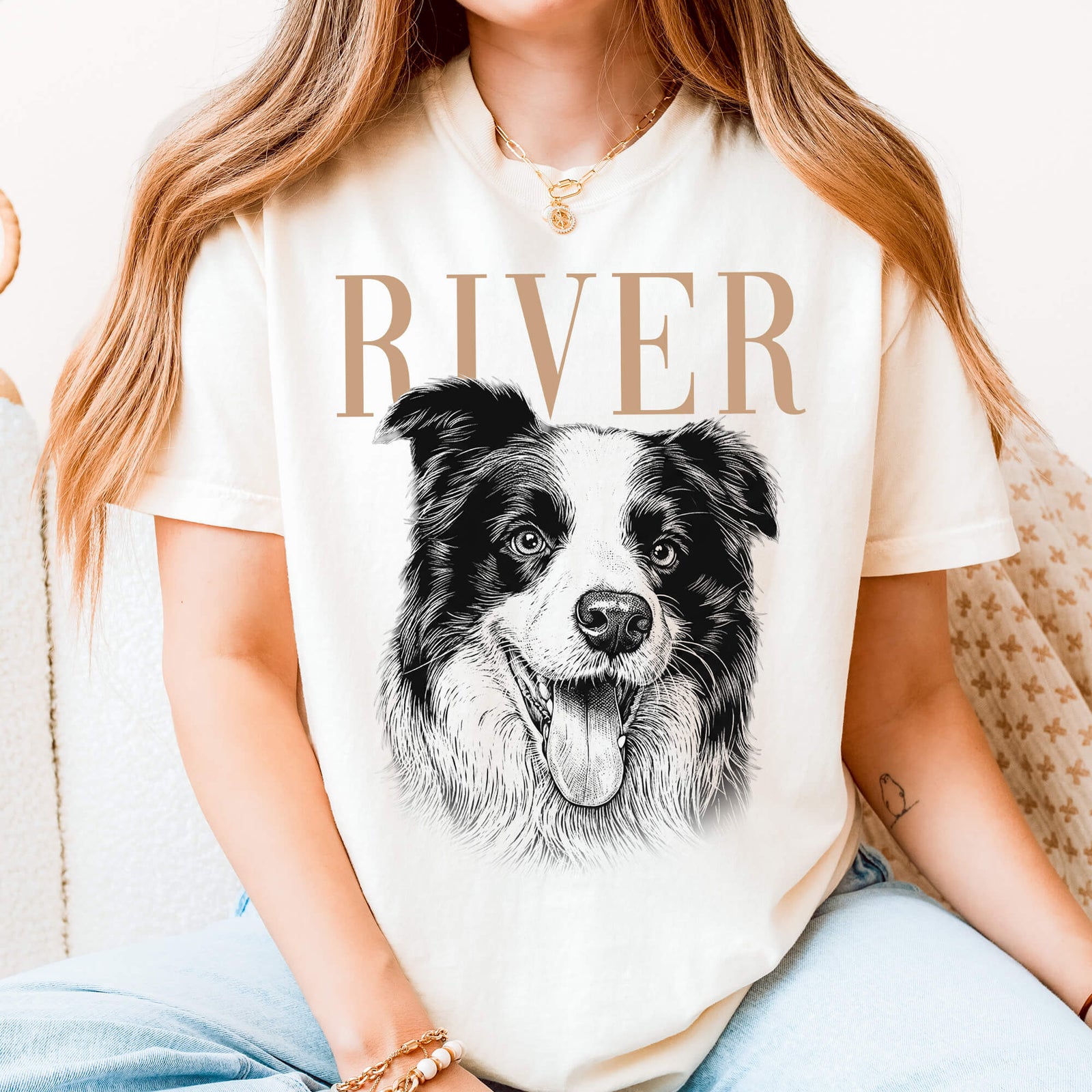 Woman wearing a white T-shirt with a detailed black-and-white portrait of a happy dog and the name RIVER in large tan lettering.